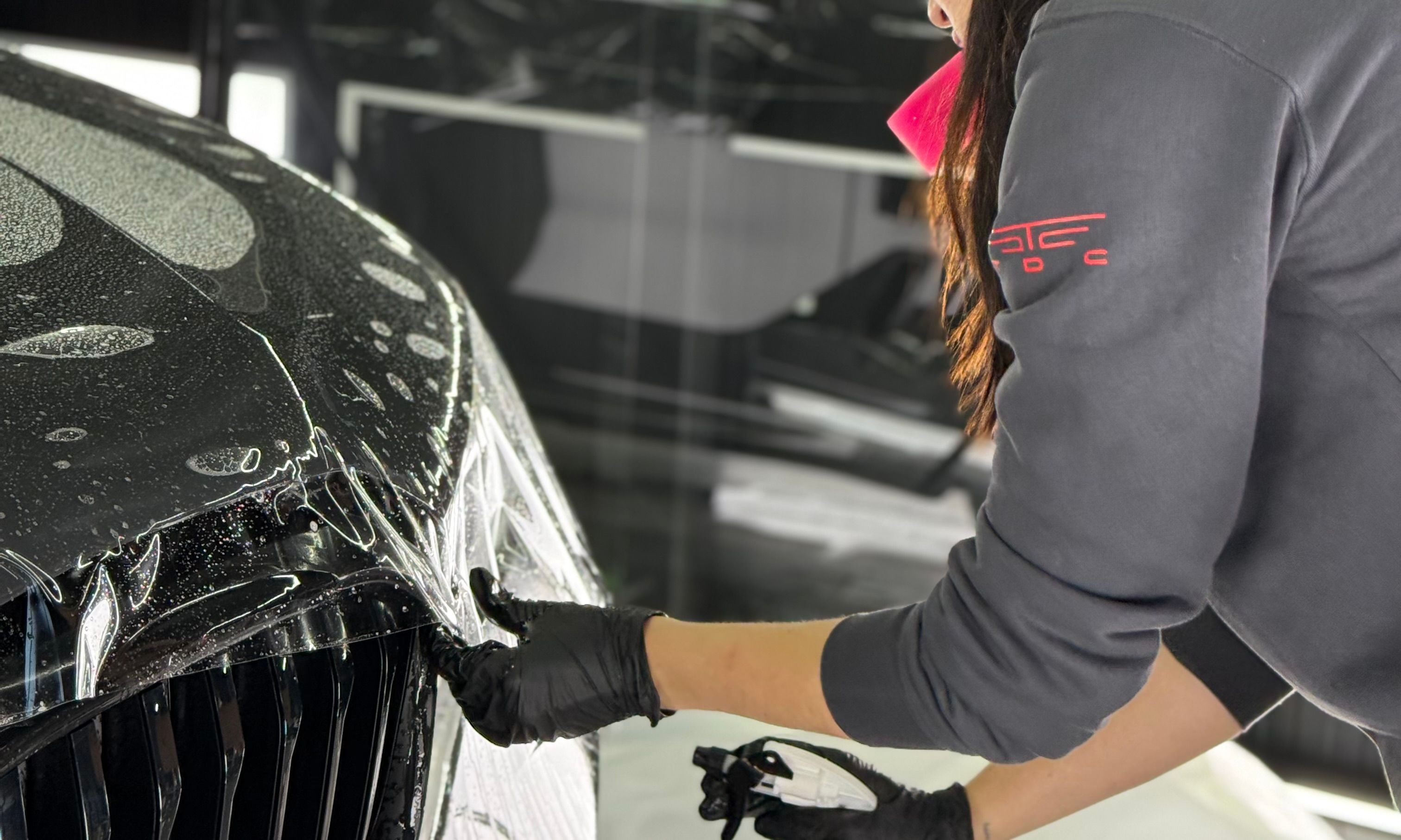 A girl is installing ppf on a car